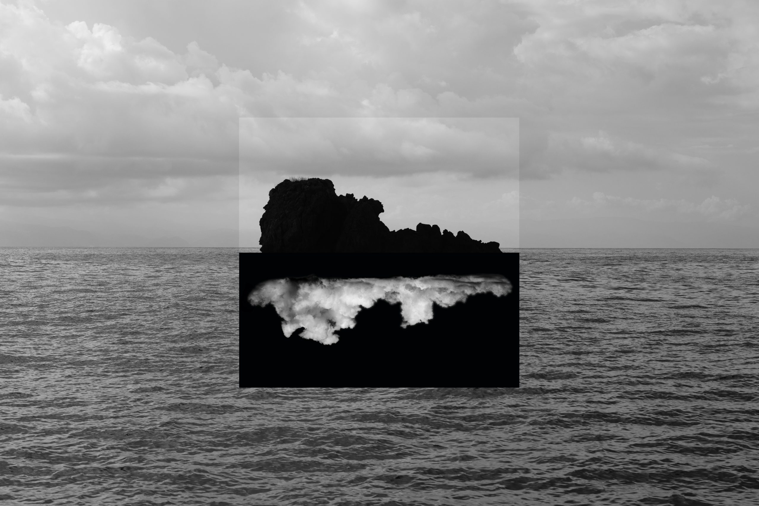 Fotografia in bianco e nero dal carattere surreale con giochi di inversione tra cielo, mare e rocce.